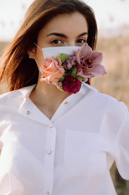 Foto covid19 linda garota em uma sessão de fotos de arte de máscara de flor