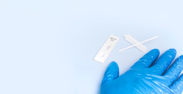 Covid19 positives Testergebnis mit SARS CoV2 Rapid Antigen Test Kit ATK auf blauem Boden mit KopierraumCoronavirus Infektionsschutzkonzept