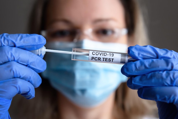 COVID19-Test in Arzthänden Nahaufnahme Frau in medizinischer Maske hält Coronavirus-Tupfer-Sammelset