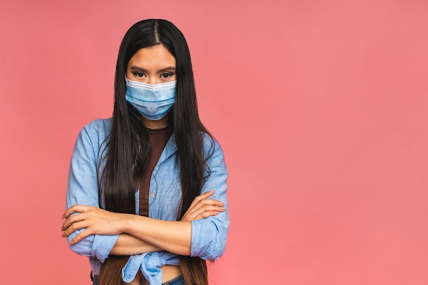 Covid19-Virus-Gesundheits- und Medizinkonzept Porträt einer jungen Asiatin mit medizinischer Schutzmaske während der Coronavirus-Quarantäne isoliert auf rosafarbenem Hintergrund