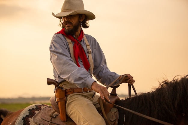 Cowboy a cavalo contra um lindo pôr do sol