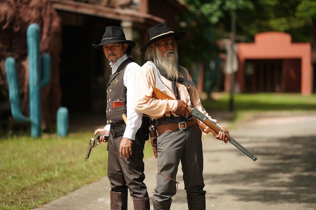 Cowboy brutal com tiroteio de revólver no fundo rural do rancho