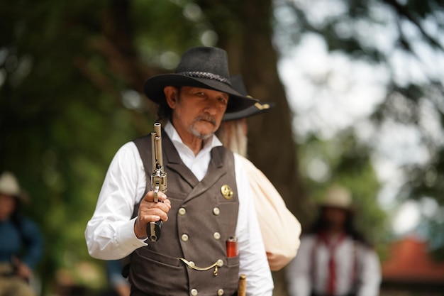 Cowboy brutal com tiroteio de revólver no fundo rural do rancho