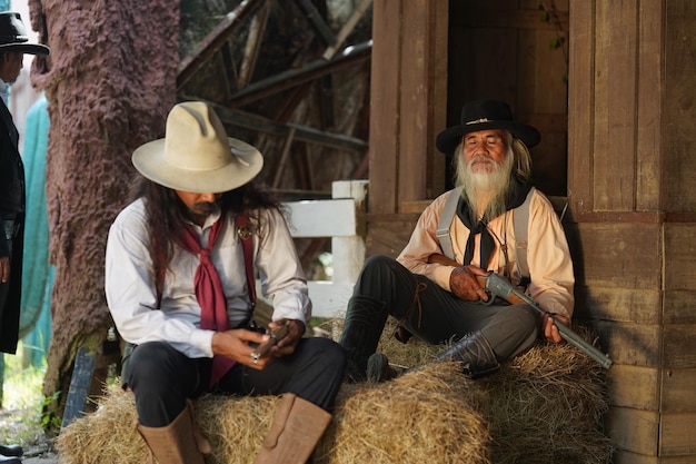 Cowboy brutal com tiroteio de revólver no fundo rural do rancho