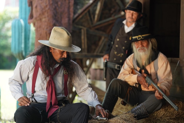 Cowboy brutal com tiroteio de revólver no fundo rural do rancho