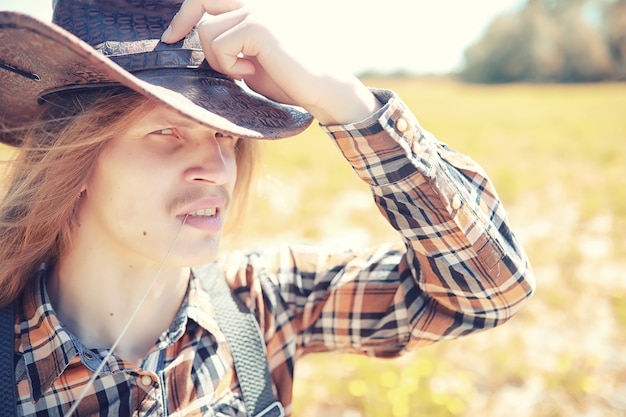 Cowboy com chapéu em um campo no outono