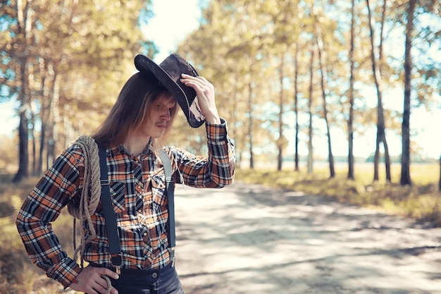 Cowboy com chapéu em um campo no outono