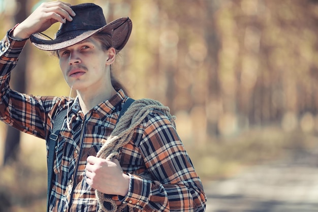 Cowboy com chapéu em um campo no outono