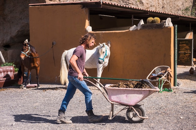 Cowboy Mann, der in der Farm mit Pferden arbeitet.