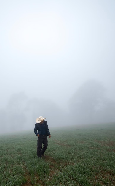 Cowboy-Mann geht durch einen nebligen Wald mit Platz für Text