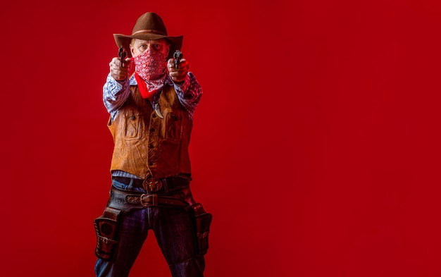 Cowboy mit einer Pistole, ein Typ mit einem Cowboy-Hut, mit einer Waffe, ein Western-Mann mit einem Hut, ein amerikanischer Bauer.