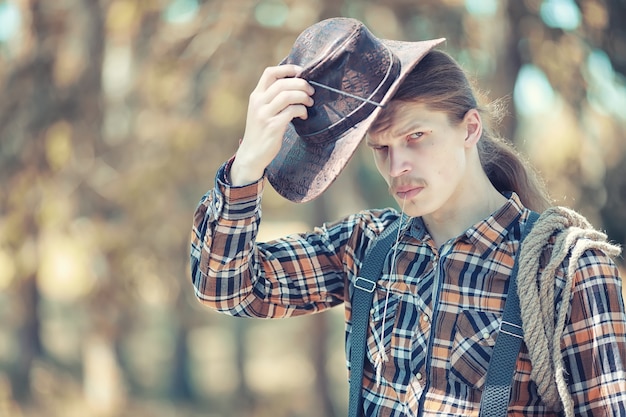 Cowboy mit Hut auf einem Feld im Herbst