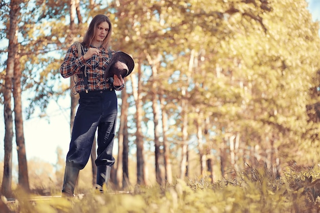 Cowboy mit Hut auf einem Feld im Herbst