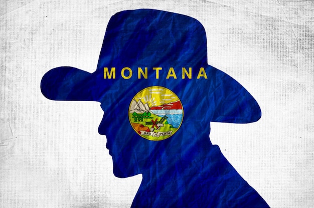 Cowboy-Silhouette mit Montana-Flagge auf zerknittertem Papierhintergrund