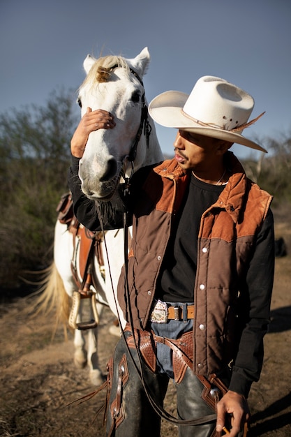 Foto cowboy-silhouette mit pferd gegen warmes licht