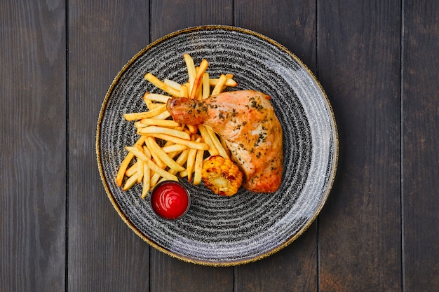 coxa de frango assada com batatas fritas perto de ketchup e milho grelhado