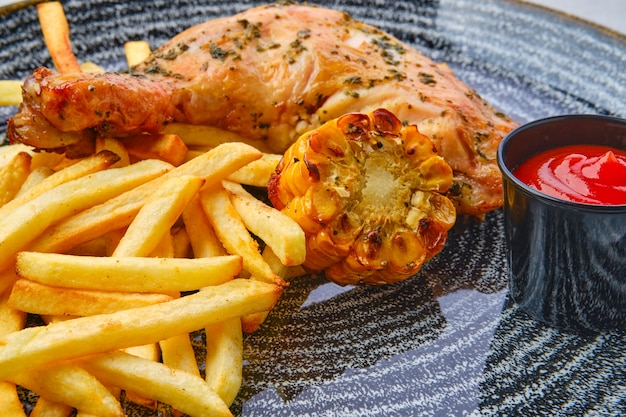 coxa de frango assada com batatas fritas perto de ketchup e milho grelhado