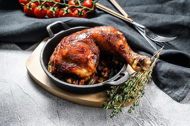 Coxa de frango assada com temperos em uma frigideira.