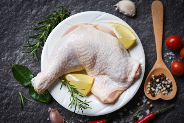 Coxa de frango cru no prato branco para cozinhar comida asiática tailandesa alecrim frango com limão