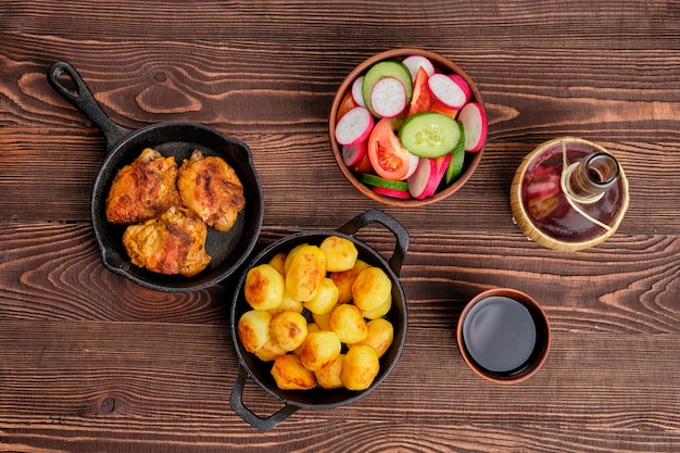 Coxas de frango assado, batata frita e salada - jantar rústico