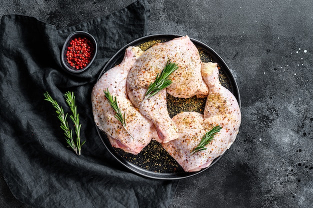 Coxas de frango cru fresco, pernas sobre uma tábua com especiarias, cozinhar.