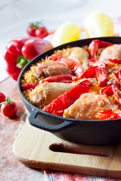 Coxas e pernas de frango assadas sobre uma cama de arroz e pimentão vermelho em uma assadeira de ferro fundido