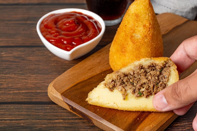 coxinha cortada por la mitad, rellena de carne