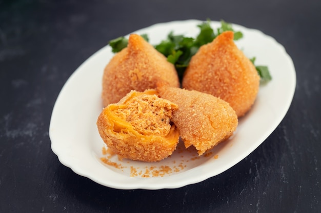 Coxinha de Frango, typisch brasilianische Hühnerkrokette auf weißem Teller