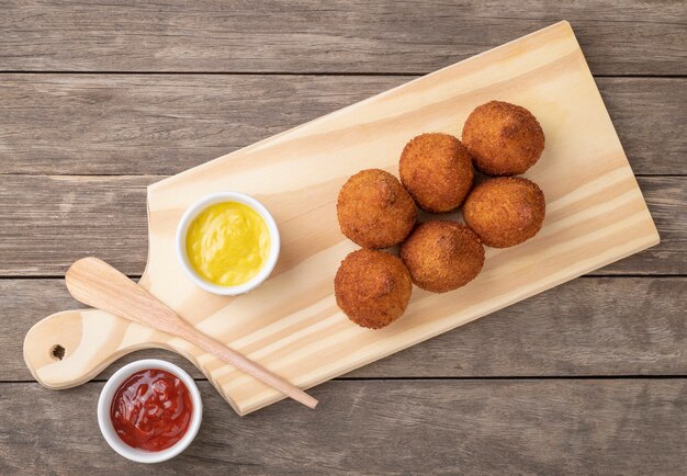 Coxinha de petisco típica brasileira em uma prancha sobre mesa de madeira.