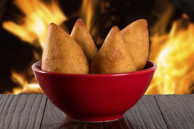 Coxinha Traditioneller brasilianischer Snack Hintergrund mit defokussiertem Feuer Hühnerkeule