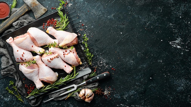 Coxinhas de frango cru com especiarias em um fundo de pedra preta Carne Vista superior Estilo rústico