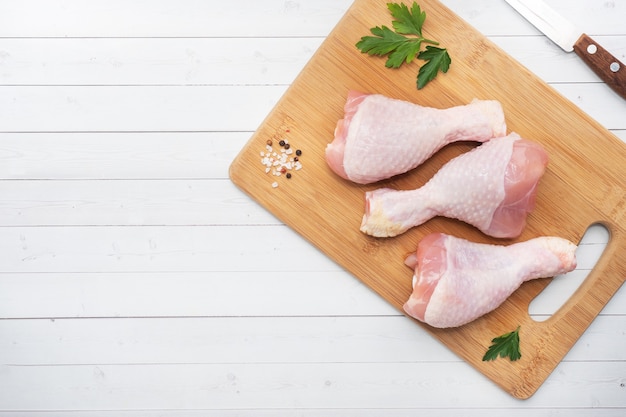 Coxinhas de frango cru com salsa e especiarias em uma tábua de madeira. vista superior copie o espaço