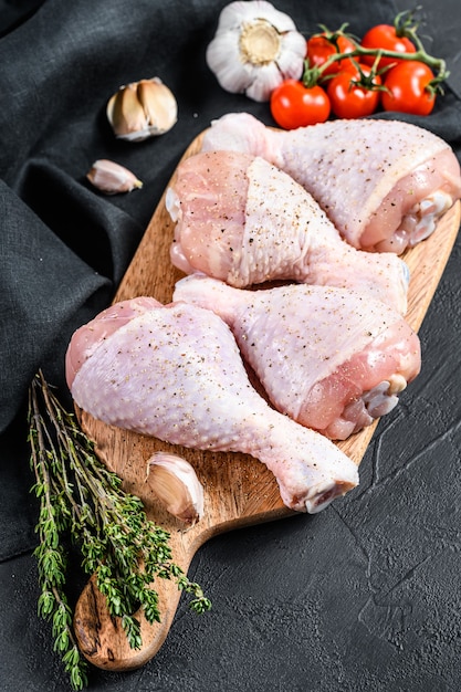 Coxinhas de frango fresco cru com especiarias e vegetais em uma tábua de madeira