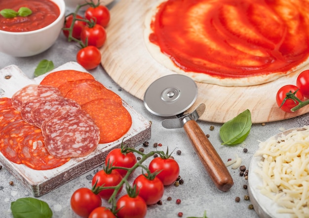 Cozimento de pizza de pepperoni com chouriço picante de salame de massa crua com cortador de roda e