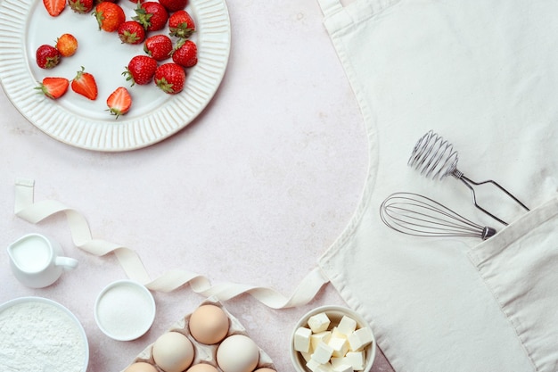 Cozimento de verão com prato de ingredientes de morangos no avental vista superior de pastelaria doce