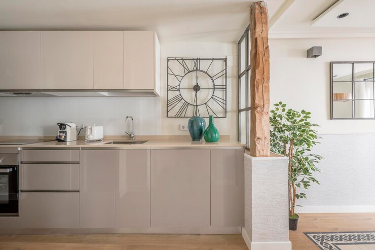 Foto cozinha aberta para sala com colunas de madeira restauradas móveis lacados a cinzento e plantas decorativas