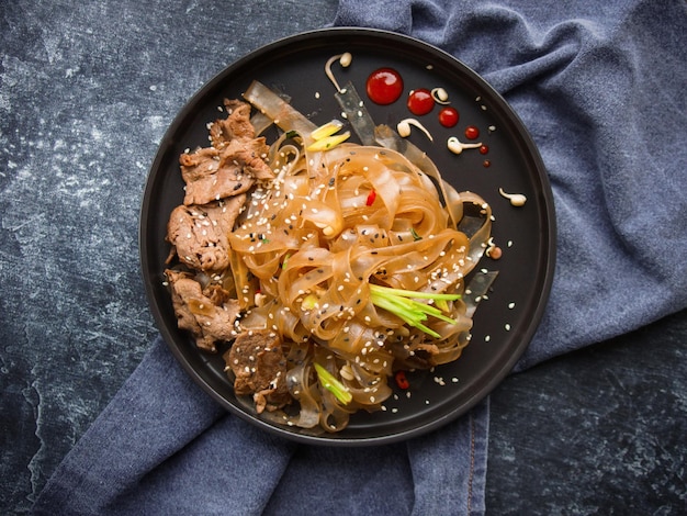 Cozinha asiática, macarrão de carne asiática picante no escuro