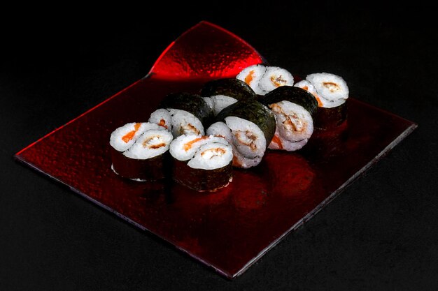 Foto cozinha asiática prato delicioso sushi sushi em um rolo de fundo preto, sua rede em um fundo preto