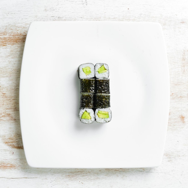 Cozinha asiática Sushi maki em um prato branco Vista superior em um fundo branco