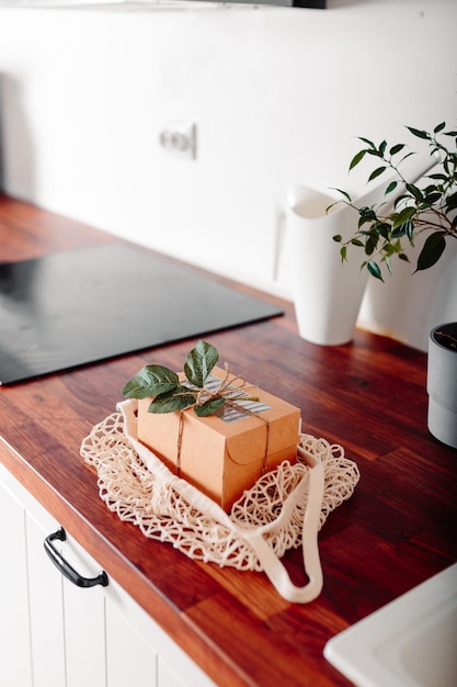 Foto cozinha branca com caixa de presente cartão de feliz páscoa com comprador de malha e caixa de presente de papel artesanal