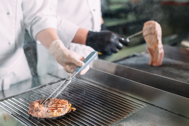 Cozinha carne assada no fogão na cozinha de um restaurante ou hotel.