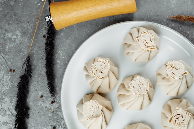 Cozinha caucasiana - Khinkali com carne em um prato branco.