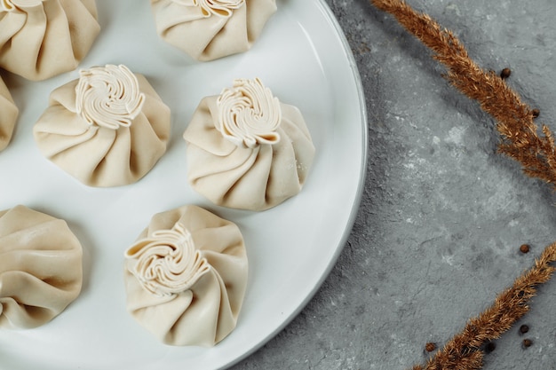 Cozinha caucasiana - Khinkali com carne em um prato branco.