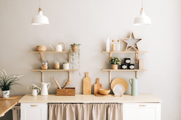 Cozinha clara em estilo provençal com pratos de madeira para plantas de casa e acessórios na mesa