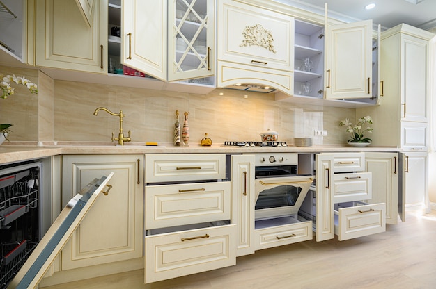Cozinha clássica contemporânea bege interior projetada em estilo provençal, todos os móveis com portas e gavetas abertas