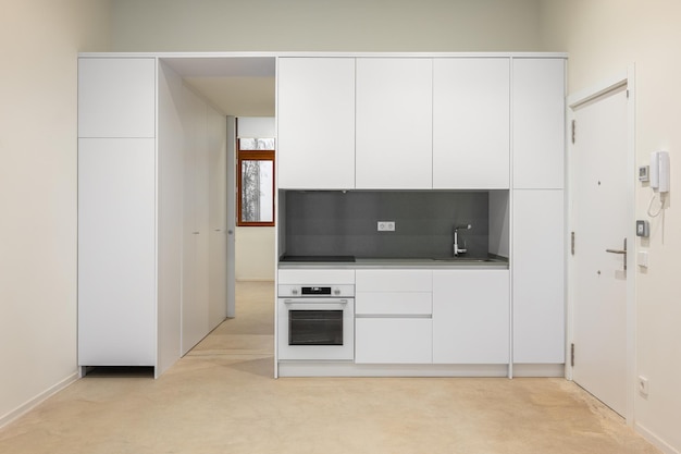 Cozinha clássica vazia branca em vista frontal em apartamento novo ou remodelado