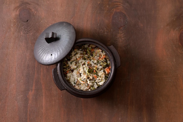 Cozinha coreana Arroz com vegetais em uma panela em um fundo de madeira