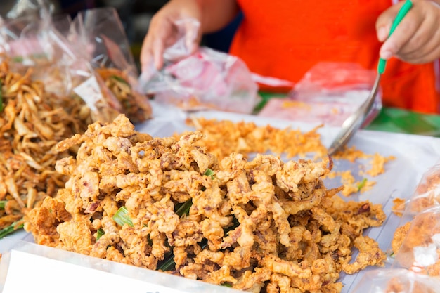 Cozinha, cozinha asiática, conceito de venda e comida - close-up de mãos de cozinheiro e lanches no mercado de rua