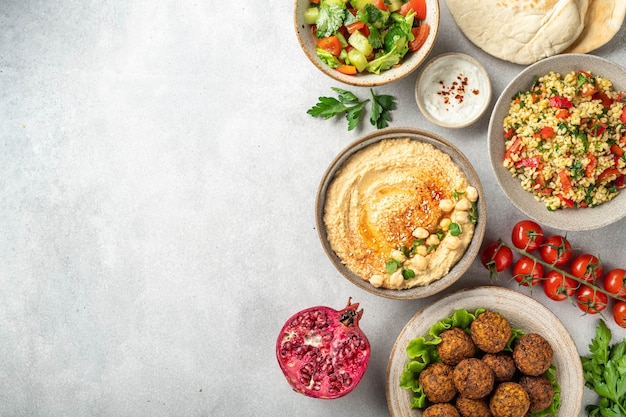 Cozinha do Oriente Médio ou árabe falafel hummus tabouleh pita e vegetais em um plano de fundo de concreto vista de cima cópia espaço