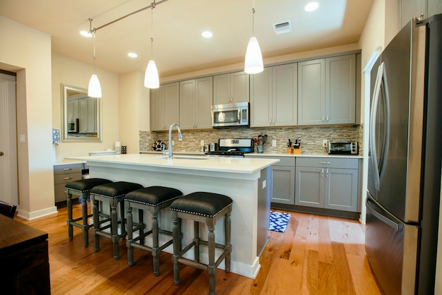 Cozinha doméstica moderna com unidades equipadas cinza verdes e ilha de cozinha